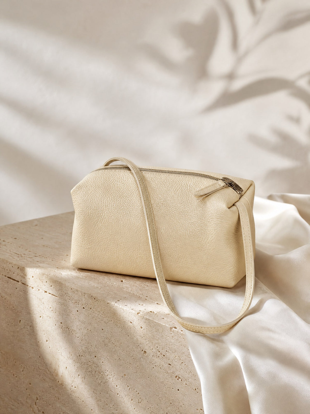 Petite Coussin Top-Handle, styled on travertine