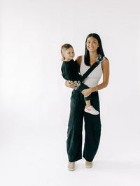Toddler carried on the hip in the Tushbaby LiftOff sling