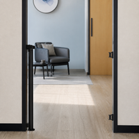 Retractable pet gate rolled into its wall post with the doorway clear