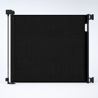 Black retractable mesh pet gate fully extended on a cool white background