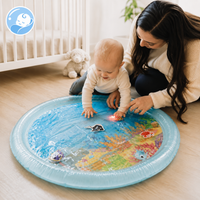 Parent kneeling alongside a baby doing tummy time on the mat