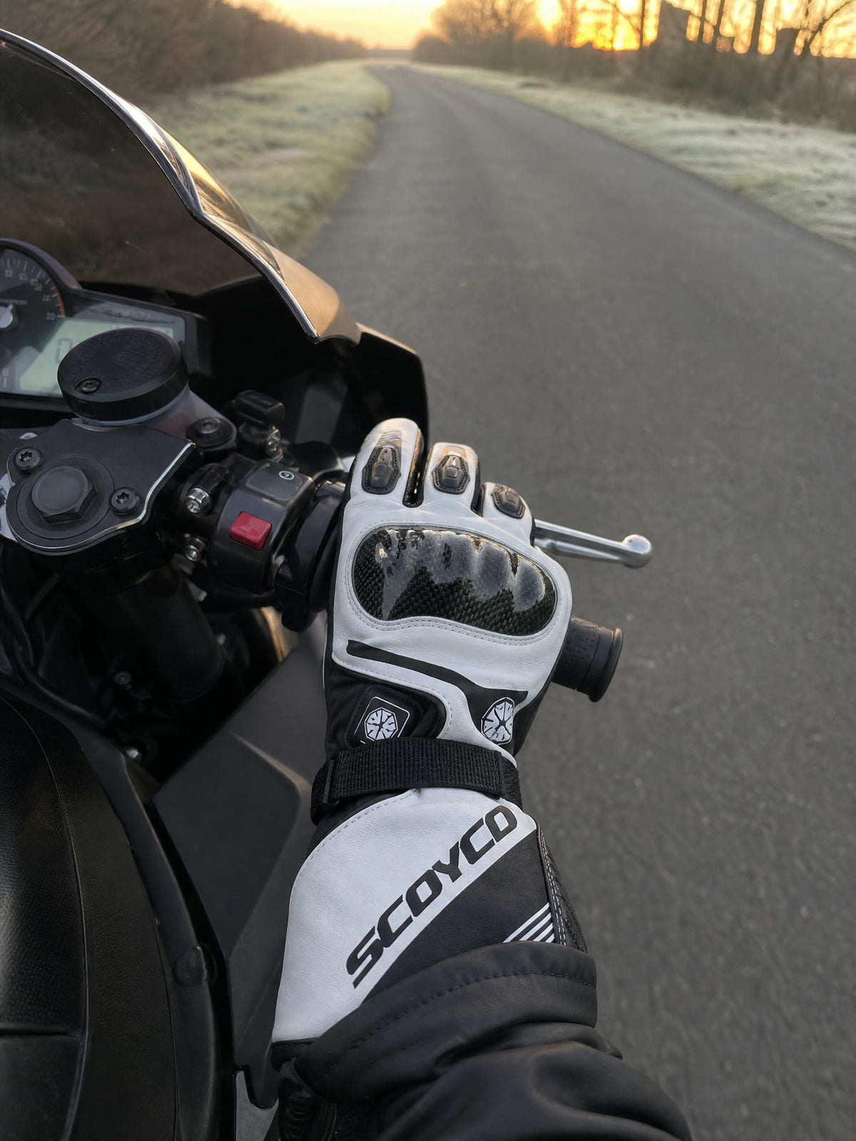 Rider's view over the bars on a frosty morning road, hands in the gloves
