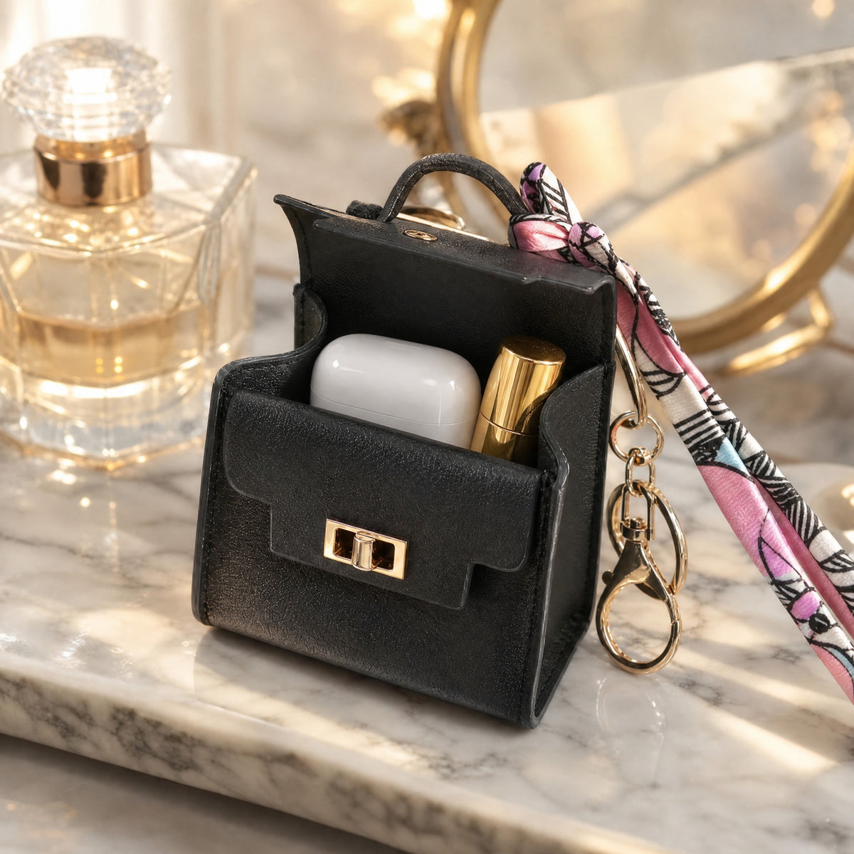 Black mini bag keychain open, holding an earbuds case and a lipstick