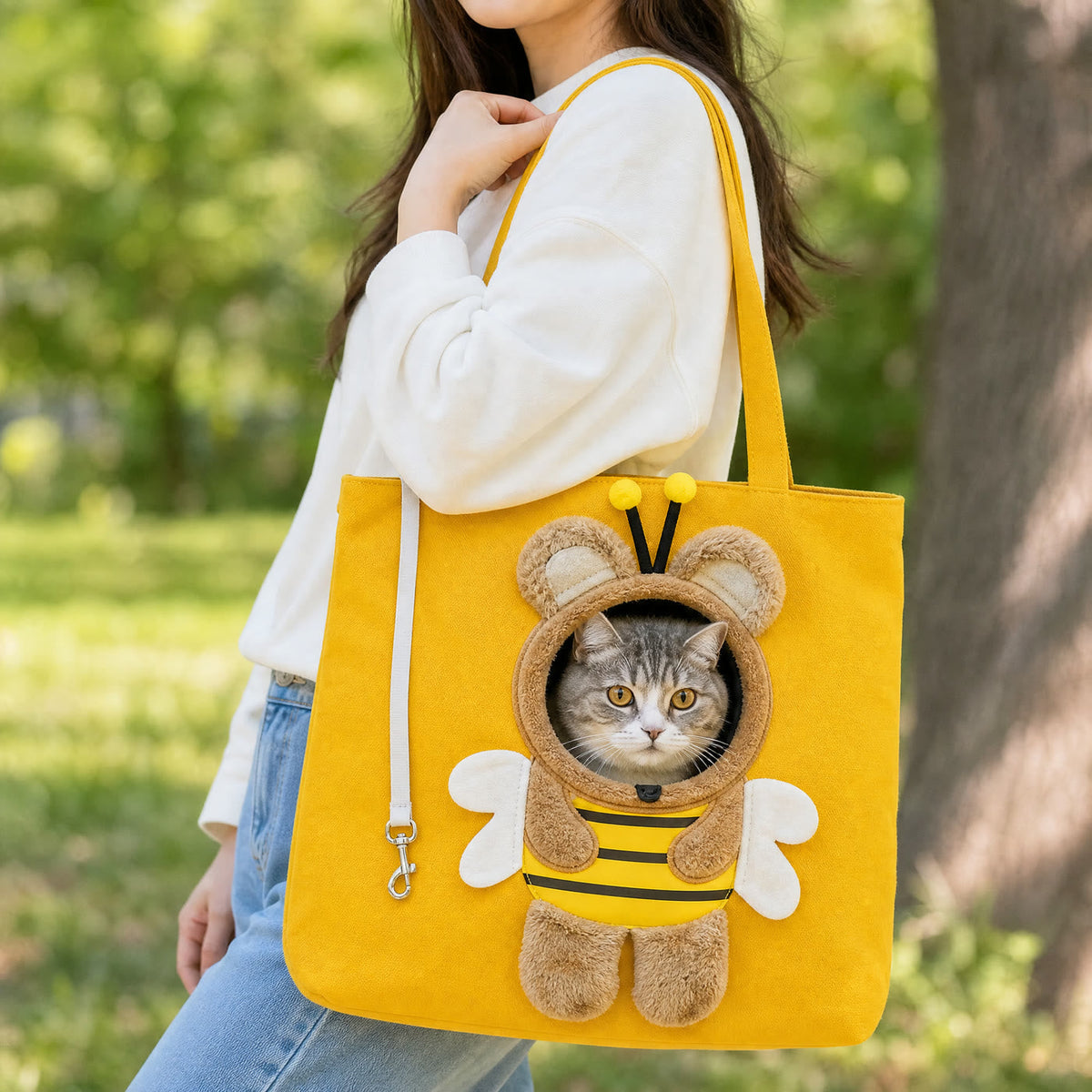 Woman carrying the yellow bee carrier tote on her shoulder with a cat looking out View 5