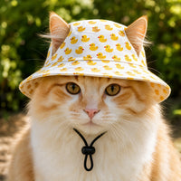 Ginger cat wearing the rubber duck sun hat outdoors with ears through the openings View 5