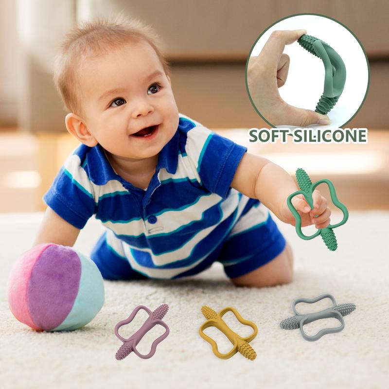 Baby holding a teether by the open ring centre