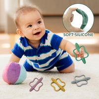Baby holding a teether by the open ring centre